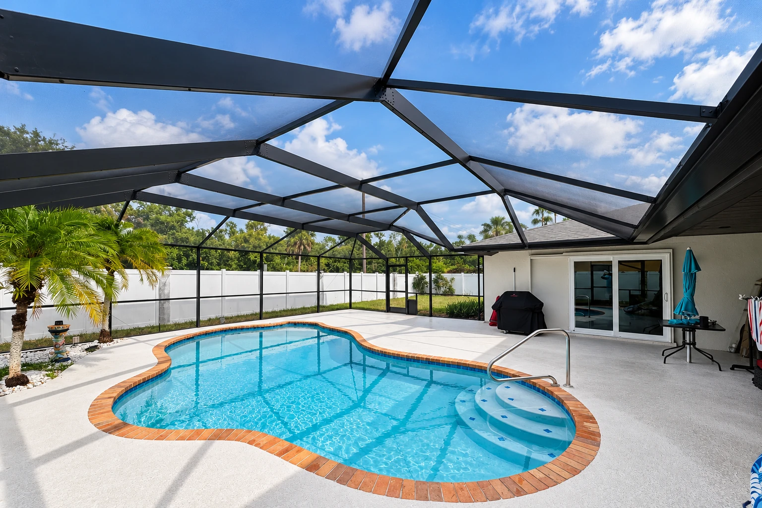 Screened patio enclosure with a black metal frame over a swimming pool beside a house.